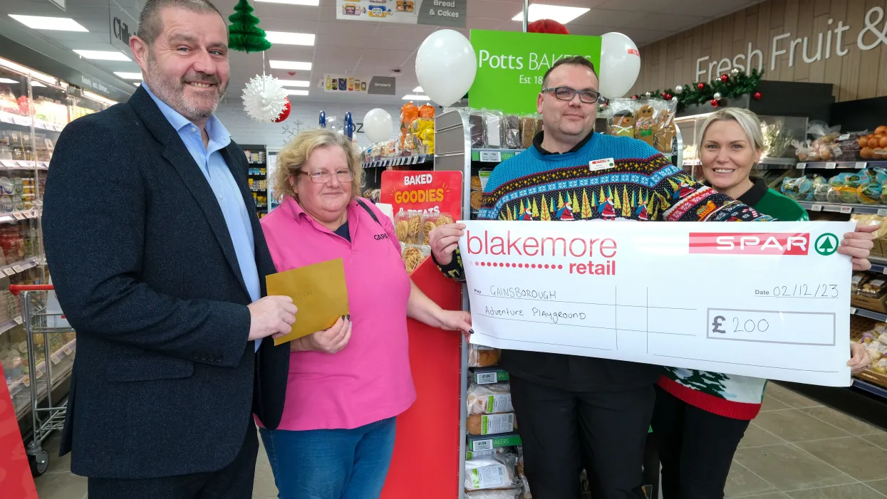 A F Blakemore staff members presenting a £200 donation to a local good cause located near a SPAR convenience store.