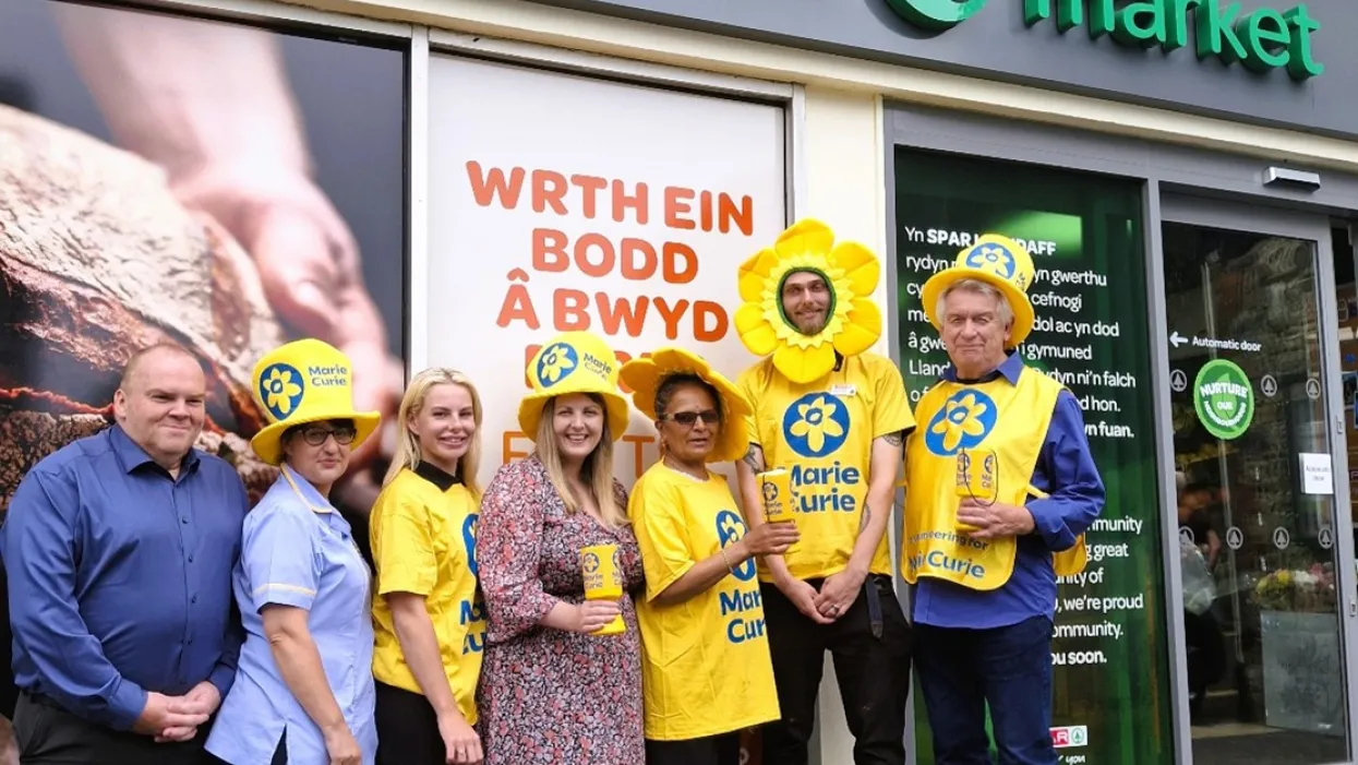SPAR store staff members fundraising for Marie Curie in front of a SPAR convenience store.