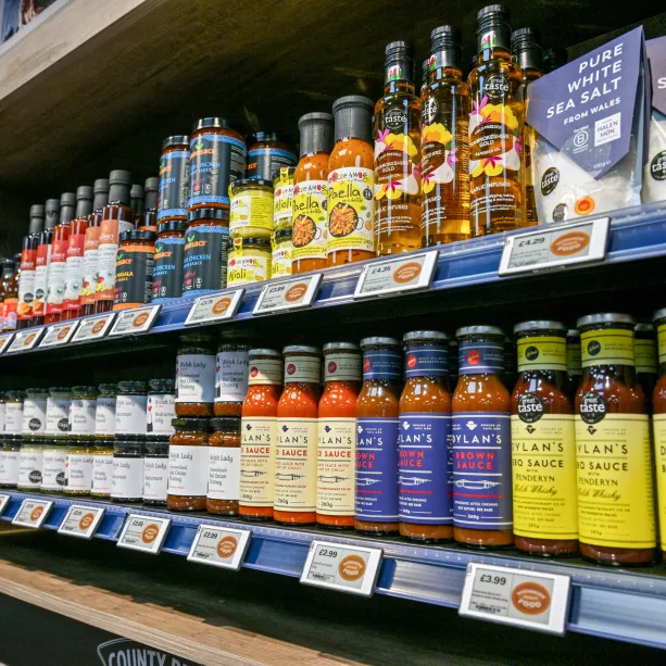 Locally sourced food and drink items on a shelf for sale in a SPAR convenience store.