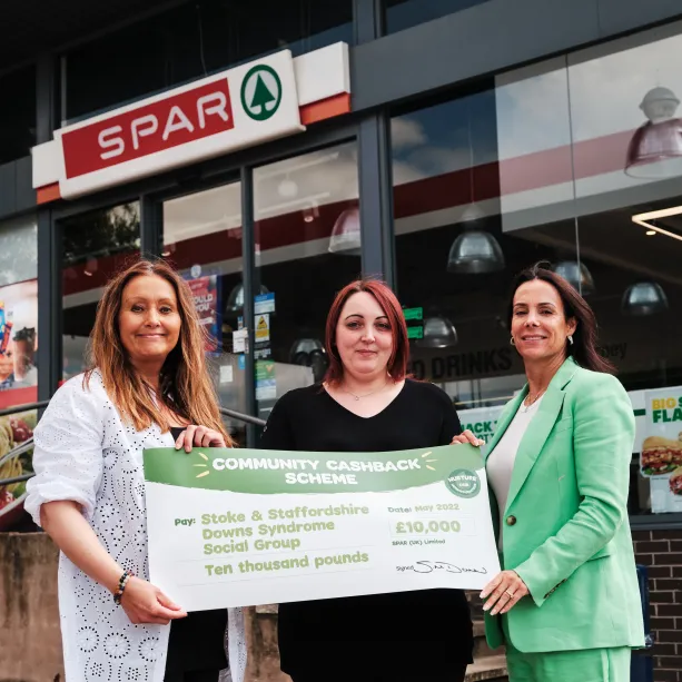 A donation cheque being presented to a local good cause by A F Blakemore staff members in front of a SPAR convenience store.