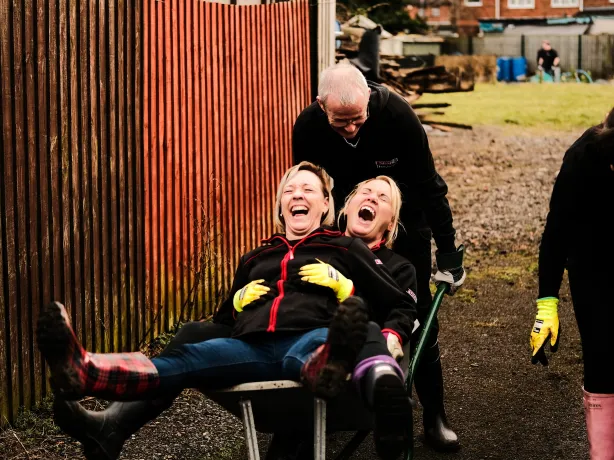 SPAR store staff members pushing a wheelbarrow at a local community project.